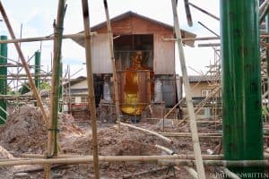 The old ubosot's Buddha statue in its protective casing.