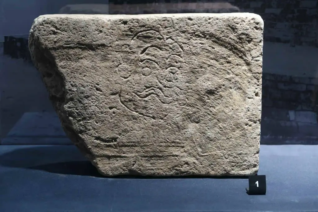 Brick engraved with a man's face excavated from Wiang Chet Lin. Currently on display at the Chiang Mai National Museum.