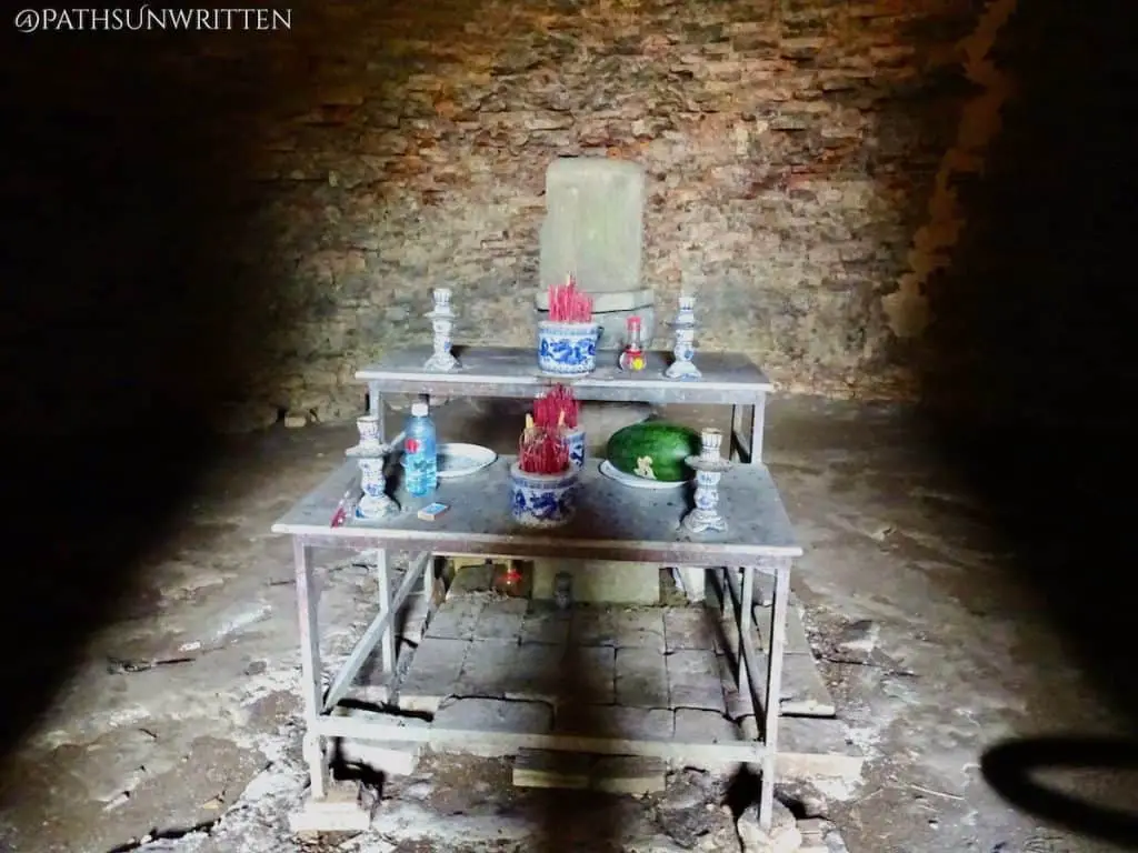 A metal altar has been placed in front of the temple's ruined lingam shrine